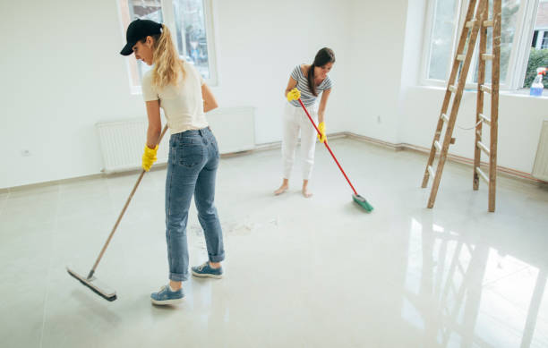 Ydelser two women cleaning floor with brush.